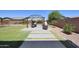 Lush backyard featuring a dining area under a pergola with a well-manicured lawn at 9750 E Radioactive Dr, Mesa, AZ 85212