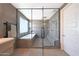 Contemporary bathroom showcasing a glass-enclosed shower and tub, complemented by sleek fixtures and gray tile at 9750 E Radioactive Dr, Mesa, AZ 85212