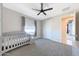 Neutral Bedroom featuring a gray crib, soft carpet, and a bright window at 9750 E Radioactive Dr, Mesa, AZ 85212