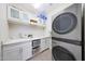 Well-organized laundry room with modern washer/dryer, ample counter space, and overhead storage cabinets at 9750 E Radioactive Dr, Mesa, AZ 85212