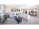 Open concept living space with white sectional sofa, modern decor, and seamless flow to dining and kitchen areas at 9750 E Radioactive Dr, Mesa, AZ 85212