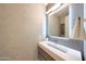 Stylish powder room featuring a modern sink, illuminated mirror, and elegant geometric wallpaper at 9750 E Radioactive Dr, Mesa, AZ 85212