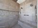 Detailed view of a luxurious shower with multiple shower heads, gray tiles, and built-in bench at 9750 E Radioactive Dr, Mesa, AZ 85212