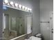 Bright bathroom featuring a glass-enclosed shower and a large vanity mirror with lighting at 9853 W Pontiac Dr, Peoria, AZ 85382