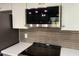 This microwave matches the backsplash, stainless-steel range, and white upper cabinets at 9853 W Pontiac Dr, Peoria, AZ 85382
