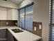 Modern kitchen sink with stainless steel faucet, light countertops, and a decorative backsplash at 9853 W Pontiac Dr, Peoria, AZ 85382