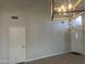 Bright living room with hardwood flooring, a modern chandelier, and a doorway ahead at 9853 W Pontiac Dr, Peoria, AZ 85382