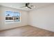 A spacious bedroom features wood floors, a ceiling fan, and a large window with a neighborhood view at 1030 E Wescott Dr, Phoenix, AZ 85024