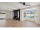 Bright living room with wood floors, a modern fireplace, ceiling fan, and views of the pool in the backyard at 1030 E Wescott Dr, Phoenix, AZ 85024
