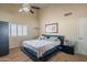 Spacious bedroom featuring neutral walls, a ceiling fan, a large bed, and shuttered windows at 10580 E Bella Vista Dr, Scottsdale, AZ 85258