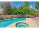 Inviting backyard pool and spa with a lush garden for relaxation and entertainment at 10580 E Bella Vista Dr, Scottsdale, AZ 85258