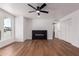 Bright living room features wood floors, a modern electric fireplace, a ceiling fan, and a window at 10610 W Diana Ave, Peoria, AZ 85345