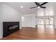 Bright living room features wood floors, a modern electric fireplace, and a ceiling fan at 10610 W Diana Ave, Peoria, AZ 85345