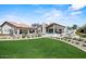 Lush backyard featuring a well manicured lawn, beautiful plants, and resort-style amenities including a pool and seating at 10755 E Cholla Ln, Scottsdale, AZ 85259