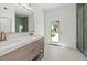 Modern bathroom with dual vanity, sleek fixtures, stylish tile, and glass enclosed shower with direct access to backyard at 10755 E Cholla Ln, Scottsdale, AZ 85259