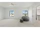 A brightly lit bedroom offering carpeted floors, a ceiling fan, and a view to the outside through large windows at 10755 E Cholla Ln, Scottsdale, AZ 85259