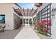 Charming courtyard with trellises, climbing roses, and inviting entry featuring beautiful landscaping and natural light at 10755 E Cholla Ln, Scottsdale, AZ 85259