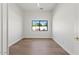 An empty room featuring new hardwood floors, fresh white paint, and a window with a serene outdoor view at 10755 E Cholla Ln, Scottsdale, AZ 85259