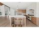Bright kitchen featuring a large island with seating, stone accent wall, and stainless steel appliances at 10755 E Cholla Ln, Scottsdale, AZ 85259