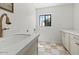 Bright laundry room with ample counter space, custom cabinets, and a window providing natural light at 10755 E Cholla Ln, Scottsdale, AZ 85259
