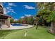 Spacious backyard with a pool, putting green, mature trees and play structure, great for Gathering fun at 1121 W Mission Dr, Chandler, AZ 85224