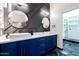 Modern bathroom featuring double sink with blue vanity, quartz countertop, and designer round mirrors at 1211 E Hayward Ave, Phoenix, AZ 85020
