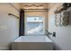 Contemporary bathroom featuring sleek freestanding tub, wall-mounted towel rack, and bright window at 1211 E Hayward Ave, Phoenix, AZ 85020