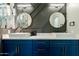 Modern bathroom featuring double sink with blue vanity, quartz countertop, and designer round mirrors at 1211 E Hayward Ave, Phoenix, AZ 85020