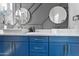 A stylish blue vanity provides a modern touch in this bathroom with double sinks and striking round mirrors at 1211 E Hayward Ave, Phoenix, AZ 85020