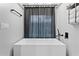 A modern bathroom featuring a sleek white soaking tub, dark hardware, and contemporary finishes at 1211 E Hayward Ave, Phoenix, AZ 85020