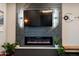 Living room fireplace and TV with decorative wall paneling and modern sconces at 1211 E Hayward Ave, Phoenix, AZ 85020