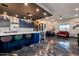 Modern kitchen with a large marble island, bold blue cabinets, and unique pendant lighting overlooking living area at 1211 E Hayward Ave, Phoenix, AZ 85020