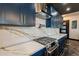 Elegant kitchen with marble countertops, stainless steel gas range, and custom blue cabinets with gold hardware at 1211 E Hayward Ave, Phoenix, AZ 85020