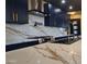 Close-up of a modern kitchen with a waterfall edge island, premium appliances, and dark blue cabinetry at 1211 E Hayward Ave, Phoenix, AZ 85020