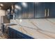 Modern kitchen showcasing the custom blue cabinetry, stainless appliances and marble countertops at 1211 E Hayward Ave, Phoenix, AZ 85020