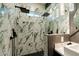 Modern shower featuring marble-look tiles, dual shower heads, window and black hexagon tile flooring at 1211 E Hayward Ave, Phoenix, AZ 85020