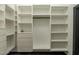 Bright walk-in closet featuring custom white shelving, cabinets and black metal hanging rods at 1211 E Hayward Ave, Phoenix, AZ 85020