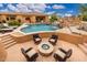 Beautiful backyard with a pool, waterfall feature, and cozy fire pit seating area at 13206 N 64Th St, Scottsdale, AZ 85254