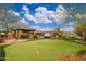 Expansive backyard featuring a putting green, covered patio, and lush landscaping, perfect for outdoor entertainment at 13206 N 64Th St, Scottsdale, AZ 85254