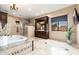 Luxurious bathroom with a soaking tub, elegant vanity, and a separate glass-enclosed shower for relaxation at 13206 N 64Th St, Scottsdale, AZ 85254