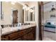 Bathroom with a double sink vanity featuring a granite countertop and dark wood cabinetry at 13206 N 64Th St, Scottsdale, AZ 85254