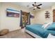 Comfortable bedroom featuring mounted TVs, wood-style floors, and a cozy bed with stylish pillows at 13206 N 64Th St, Scottsdale, AZ 85254
