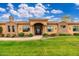 Charming home exterior showcasing beautiful stonework, lush green lawn, and an inviting front entrance at 13206 N 64Th St, Scottsdale, AZ 85254