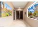 Bright hallway featuring natural light from a window overlooking the pool and a striking desert scene painting at 13206 N 64Th St, Scottsdale, AZ 85254