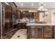 Beautiful kitchen with dark wood cabinets, granite countertops, stainless steel appliances, and a large center island at 13206 N 64Th St, Scottsdale, AZ 85254