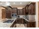 Stylish kitchen with dark wood cabinets, granite counters, and stainless steel appliances and center island at 13206 N 64Th St, Scottsdale, AZ 85254