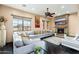 Cozy living room with stone fireplace, large windows, ceiling fan, and comfortable seating at 13206 N 64Th St, Scottsdale, AZ 85254