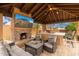 Inviting outdoor living area with a stone fireplace, comfortable seating, and a built-in grill, perfect for relaxing at 13206 N 64Th St, Scottsdale, AZ 85254