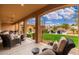 Relaxing covered patio overlooking a private backyard with a sparkling pool and lush landscaping at 13206 N 64Th St, Scottsdale, AZ 85254
