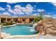 Beautiful pool with rock waterfall feature and lush landscaping perfect for outdoor enjoyment at 13206 N 64Th St, Scottsdale, AZ 85254